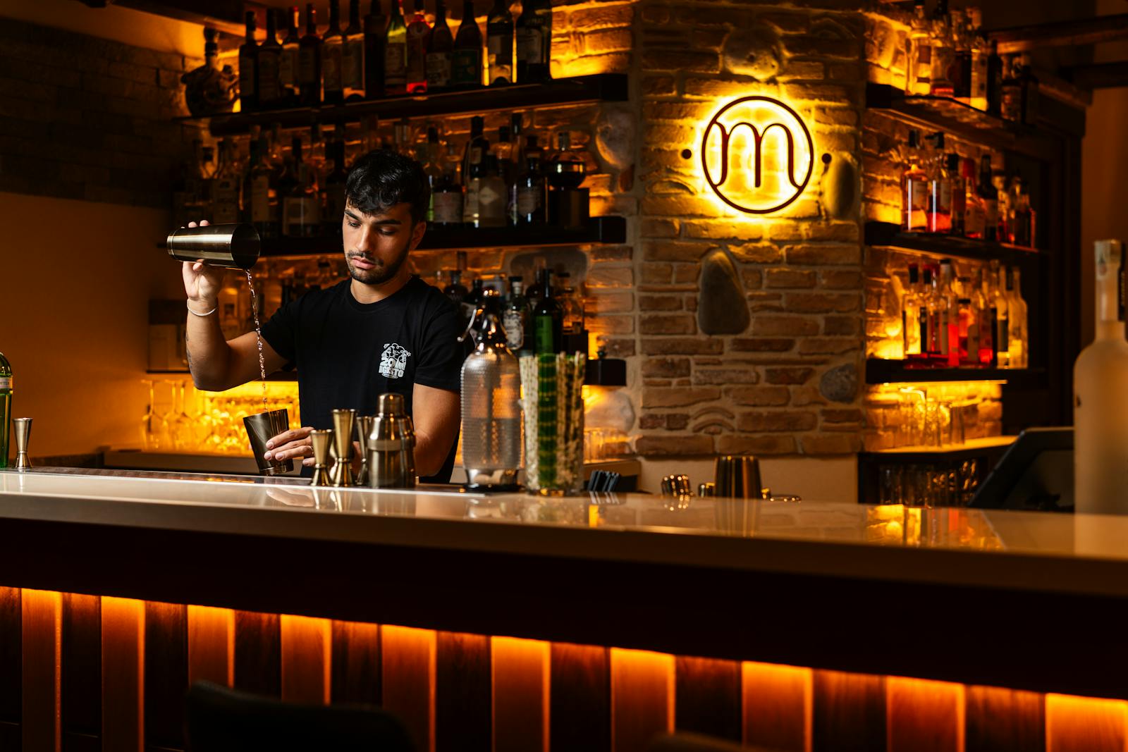 Bartender mixing drinks in a dimly lit cocktail bar