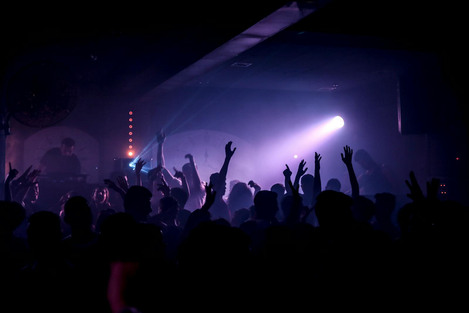 Energetic crowd dancing under spotlights at a Berlin club