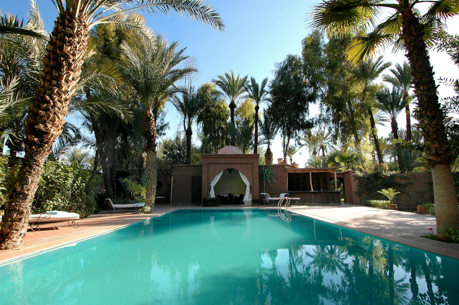 Indoor tropical resort pool with palm trees and beach