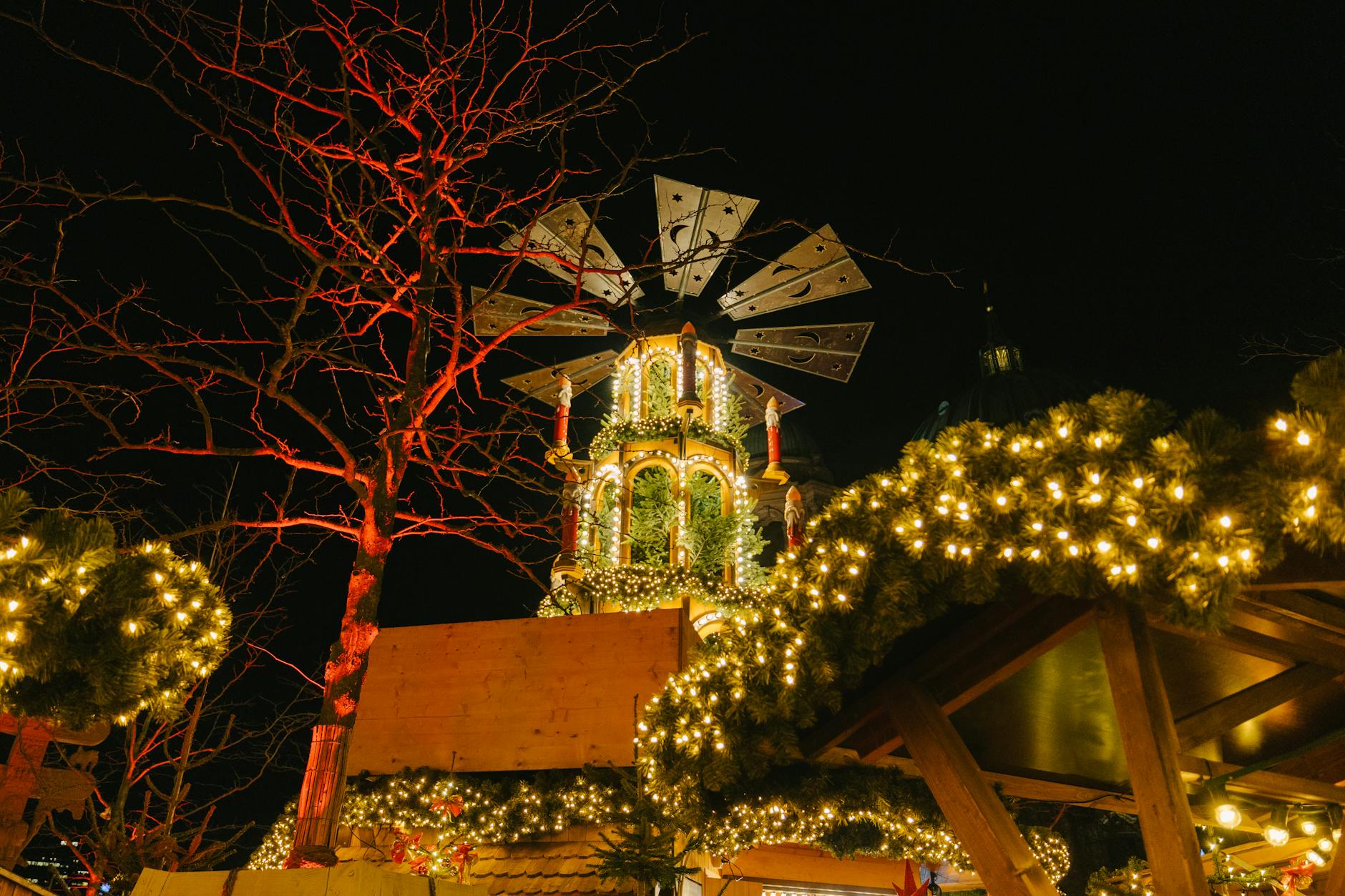 Berlin Christmas market at night with lit wooden stalls and crowds