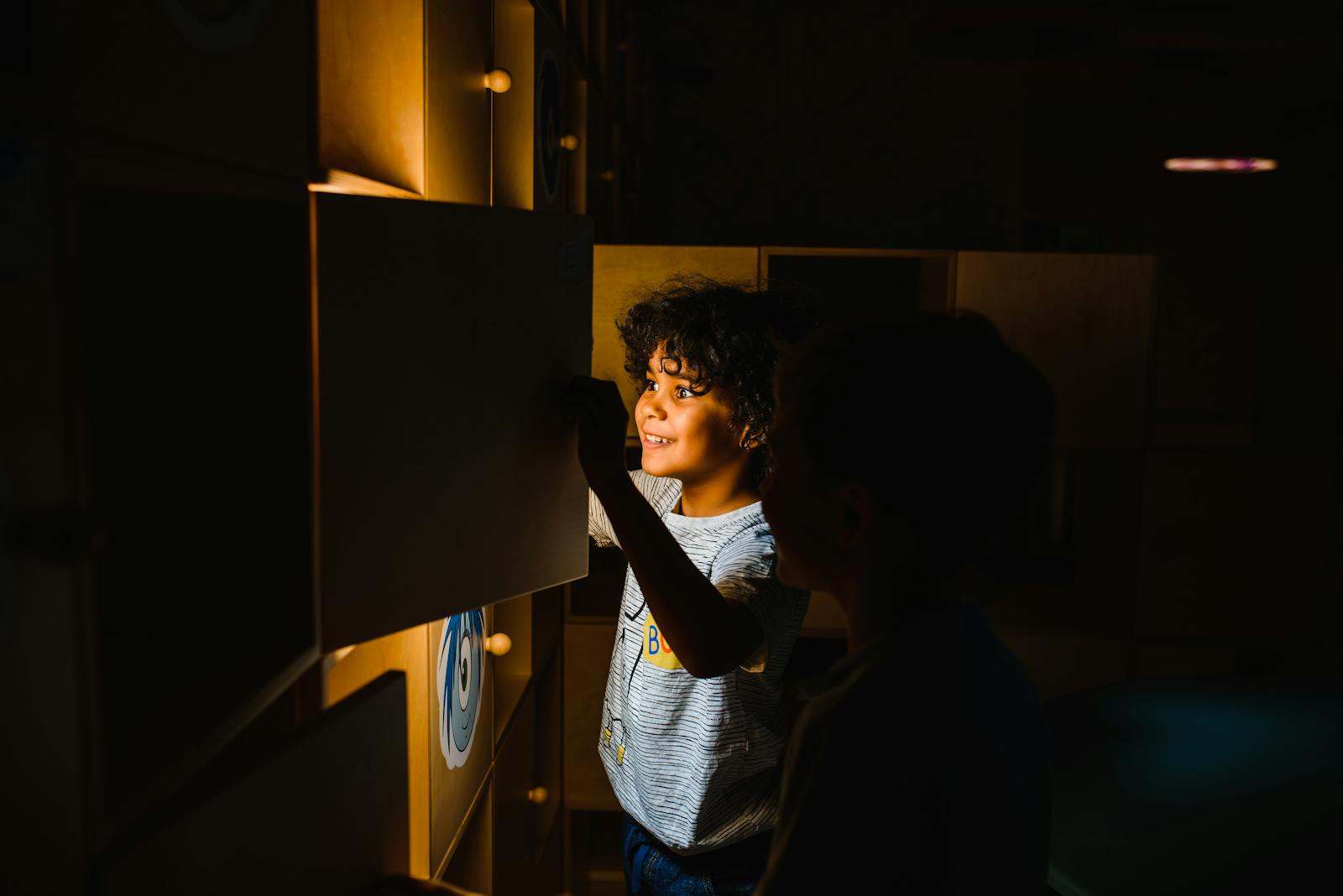 Two boys engaging with a glowing educational display