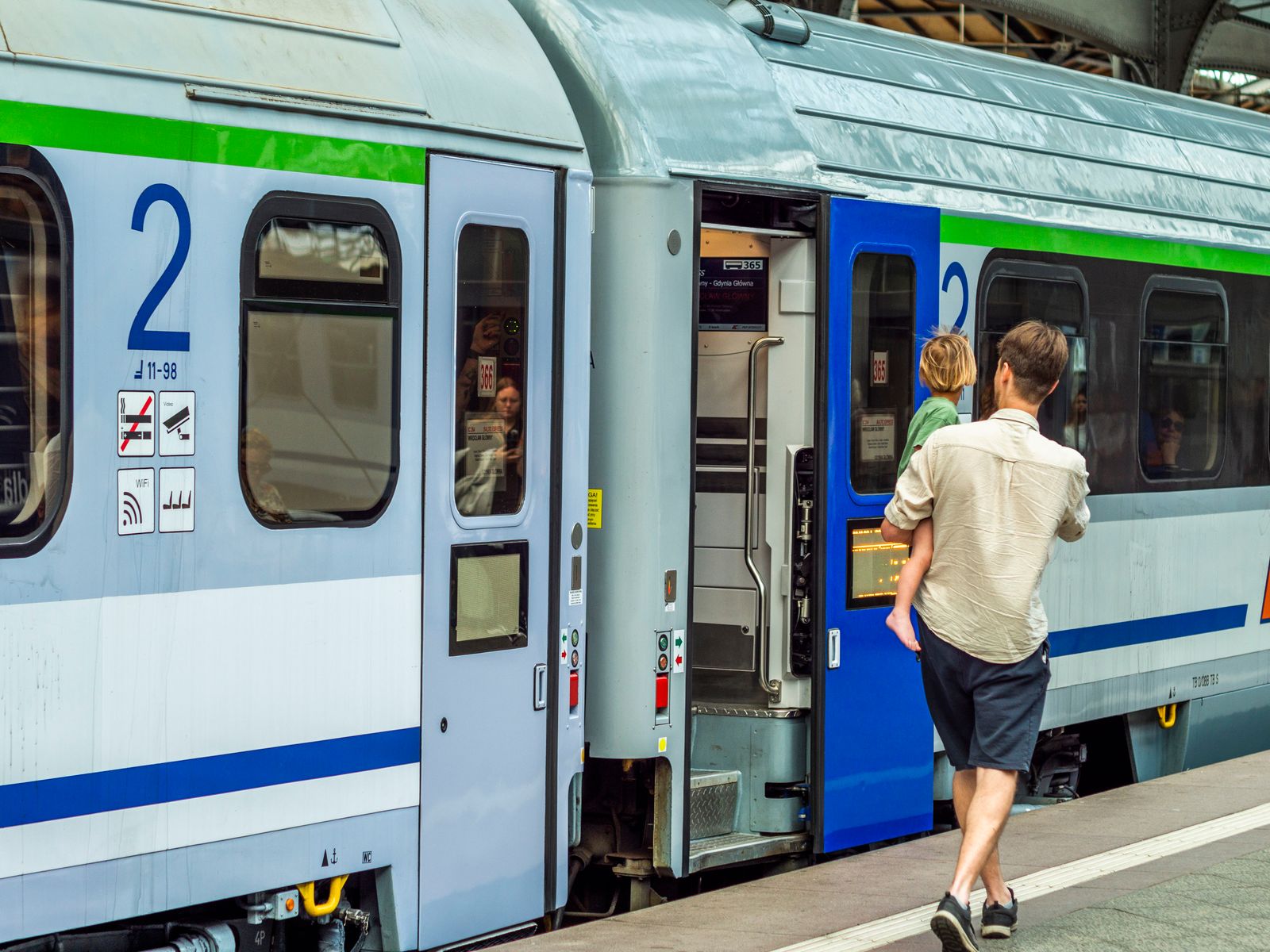 Adult and child boarding a train at the railway station