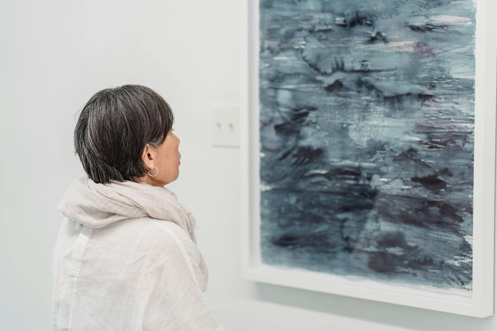 Woman looking at an abstract painting in a modern art gallery