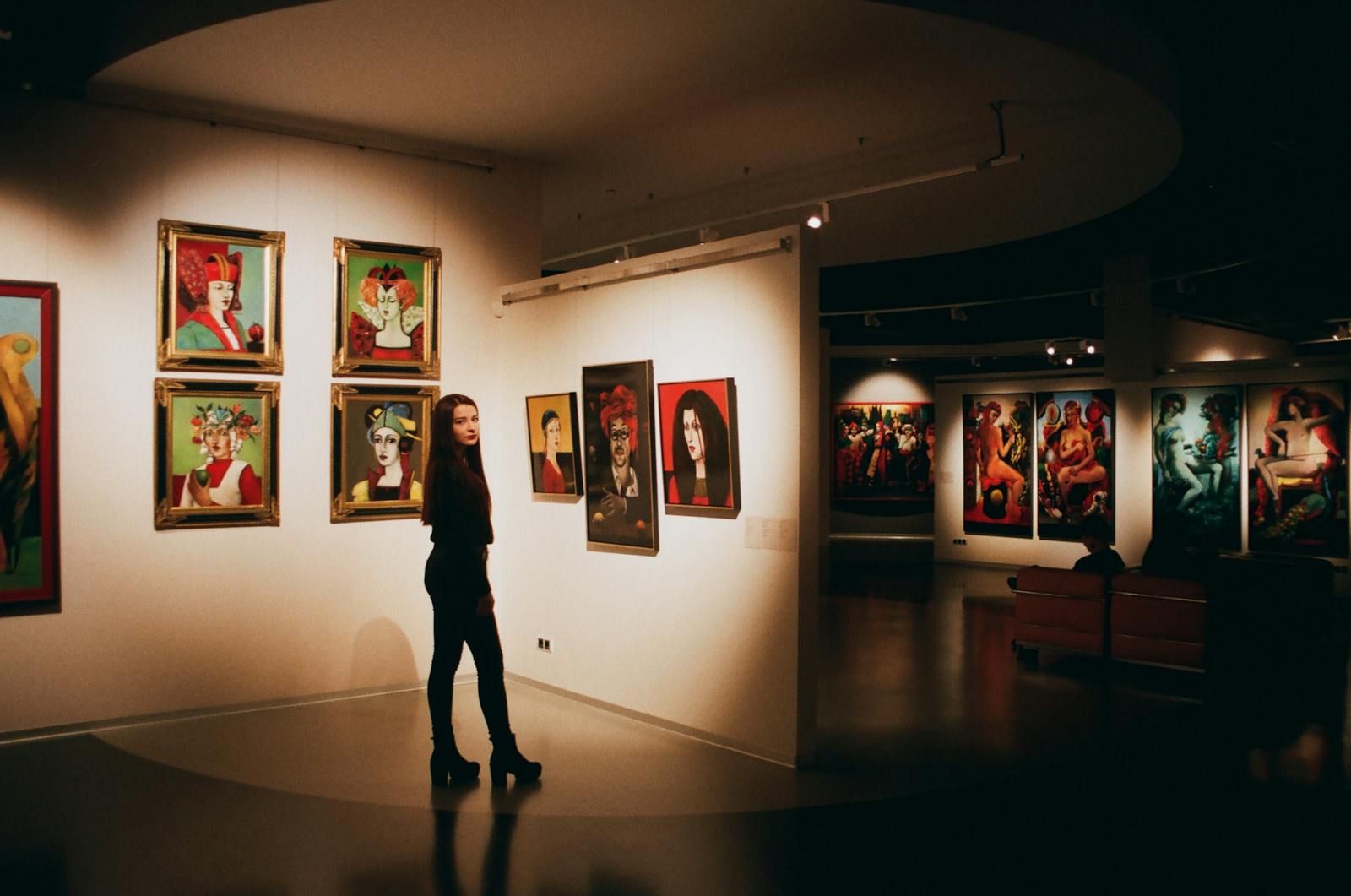 Woman admiring colorful paintings in contemporary art exhibition