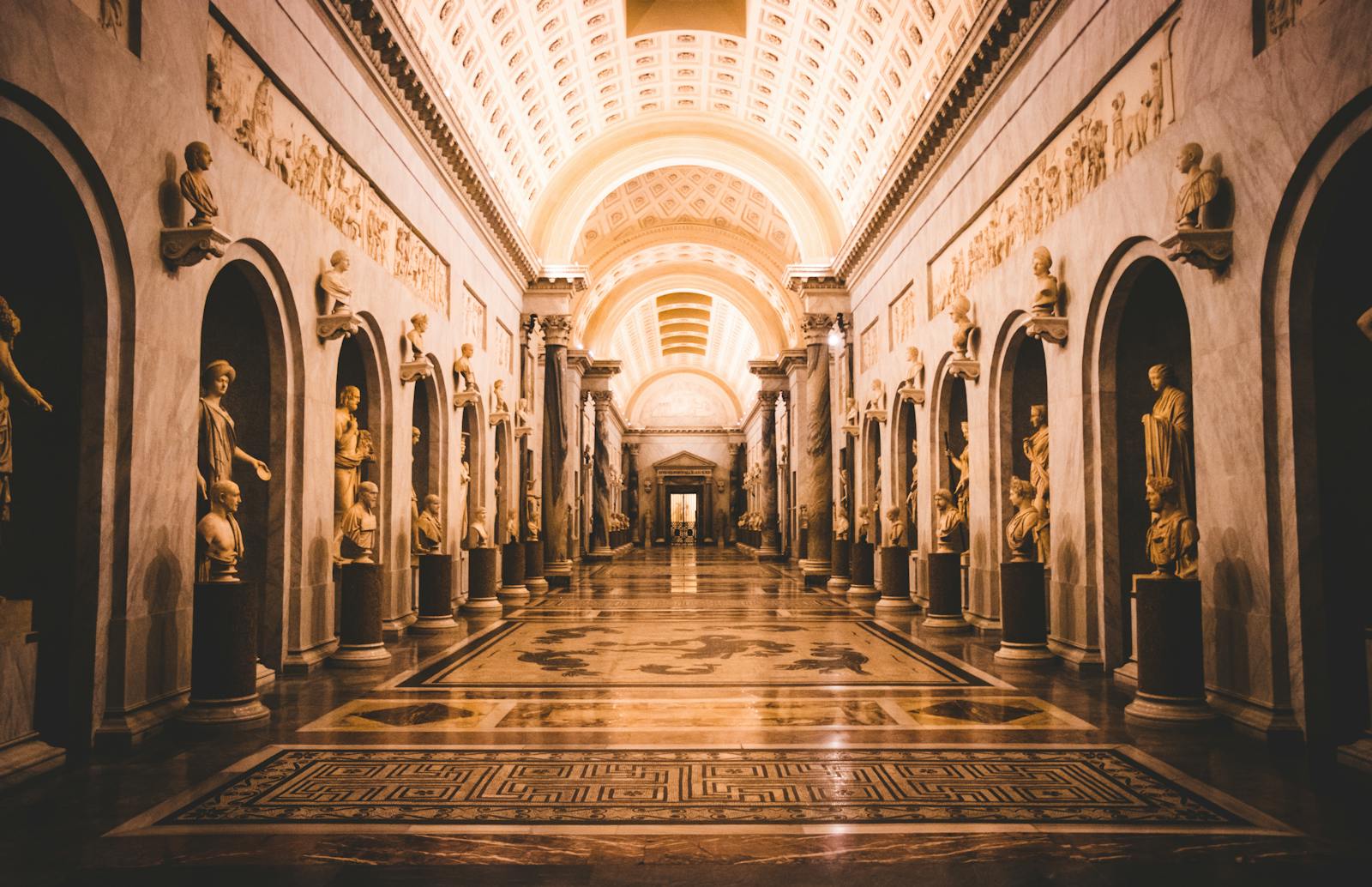 Hallway adorned with classical sculptures in a grand museum