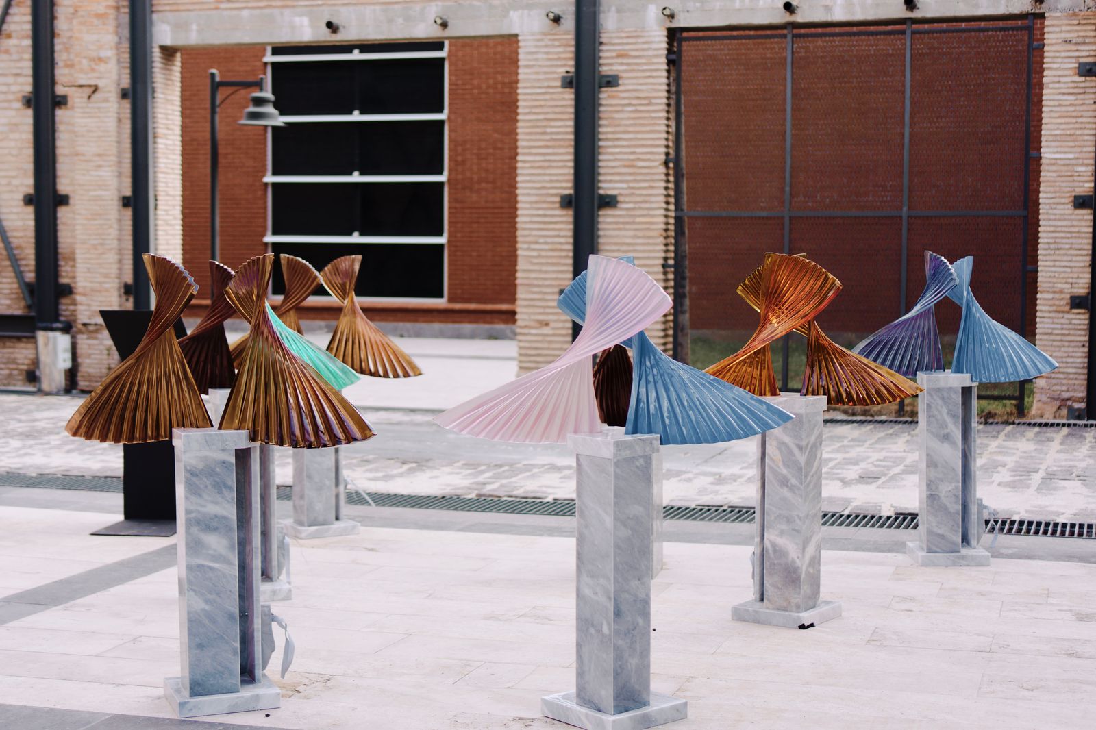 Vibrant metal sculptures displayed on marble stands
