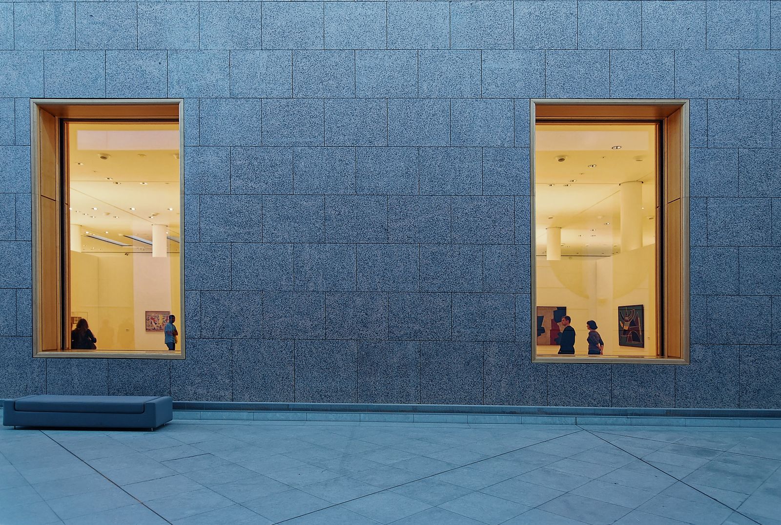 Modern art gallery exterior with large windows framing an exhibit