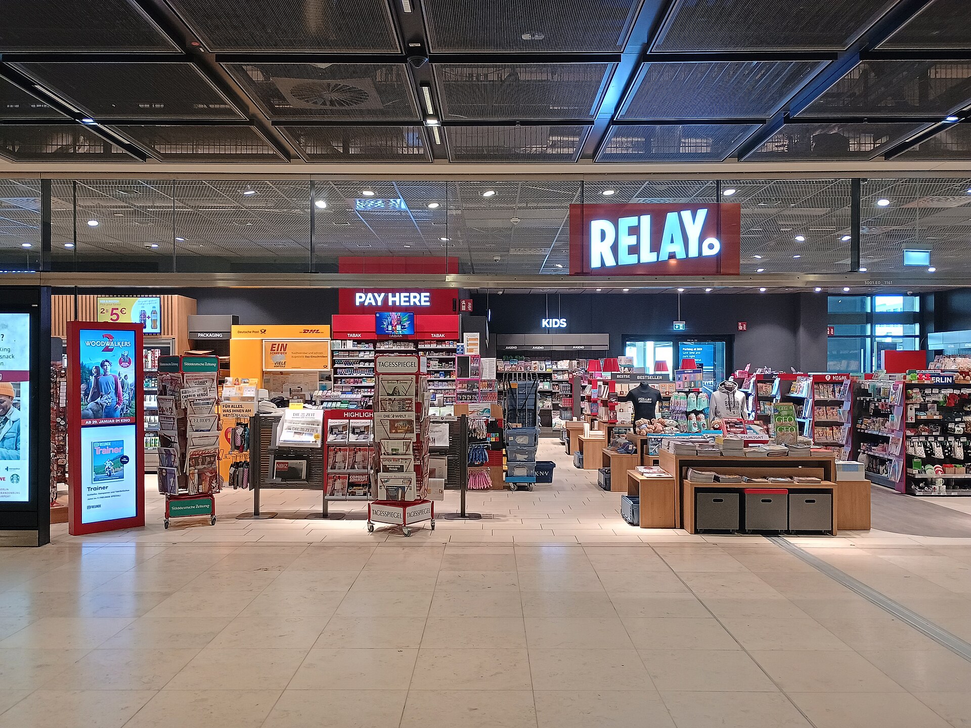 The entrance to a Relay shop in BER Terminal 1, with magazines, snacks, books and travel goods on display and a Pay Here sign