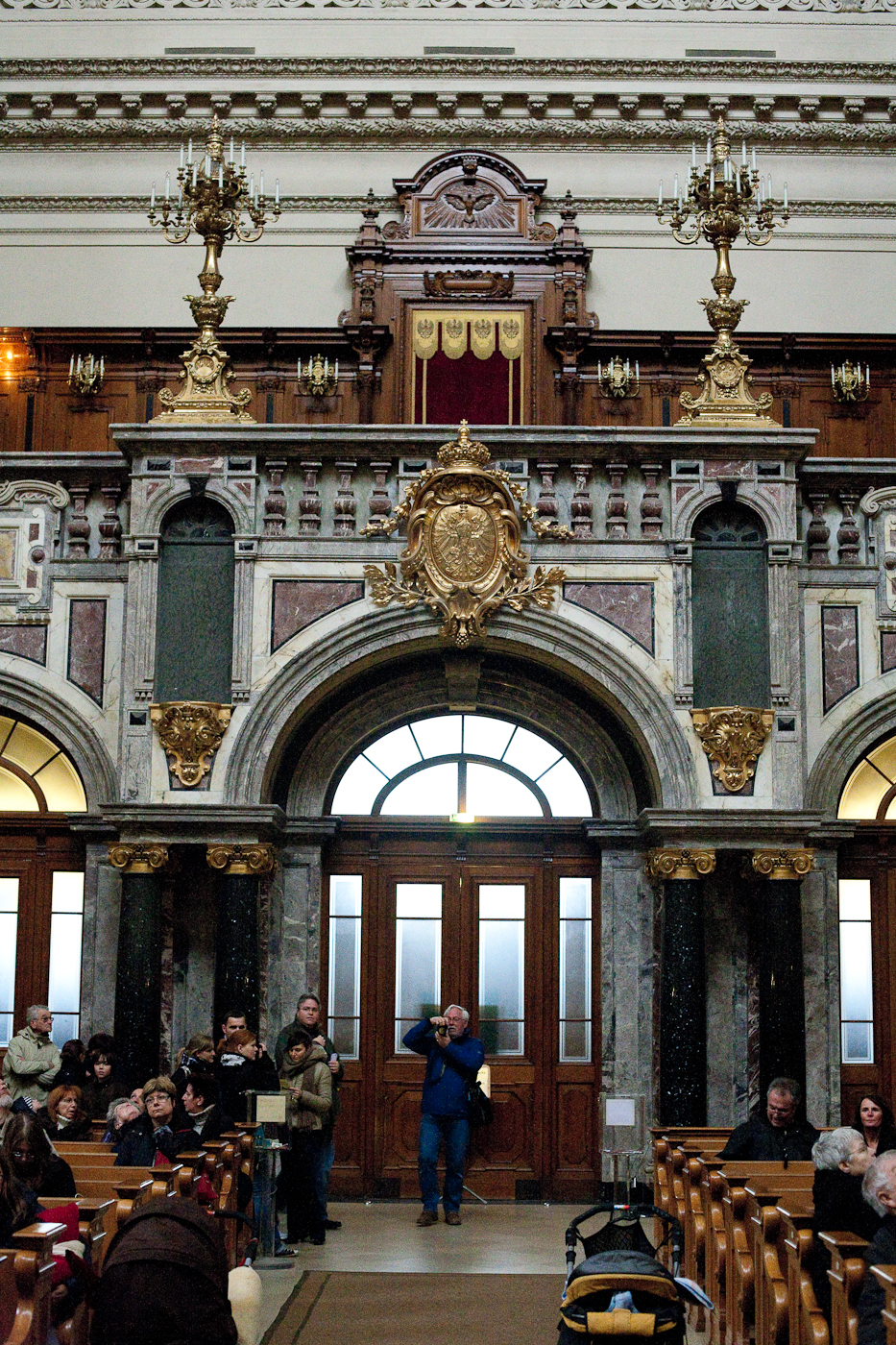 Interior of Berlin Cathedral showing the marble and gilt arcade and wooden pews with visitors