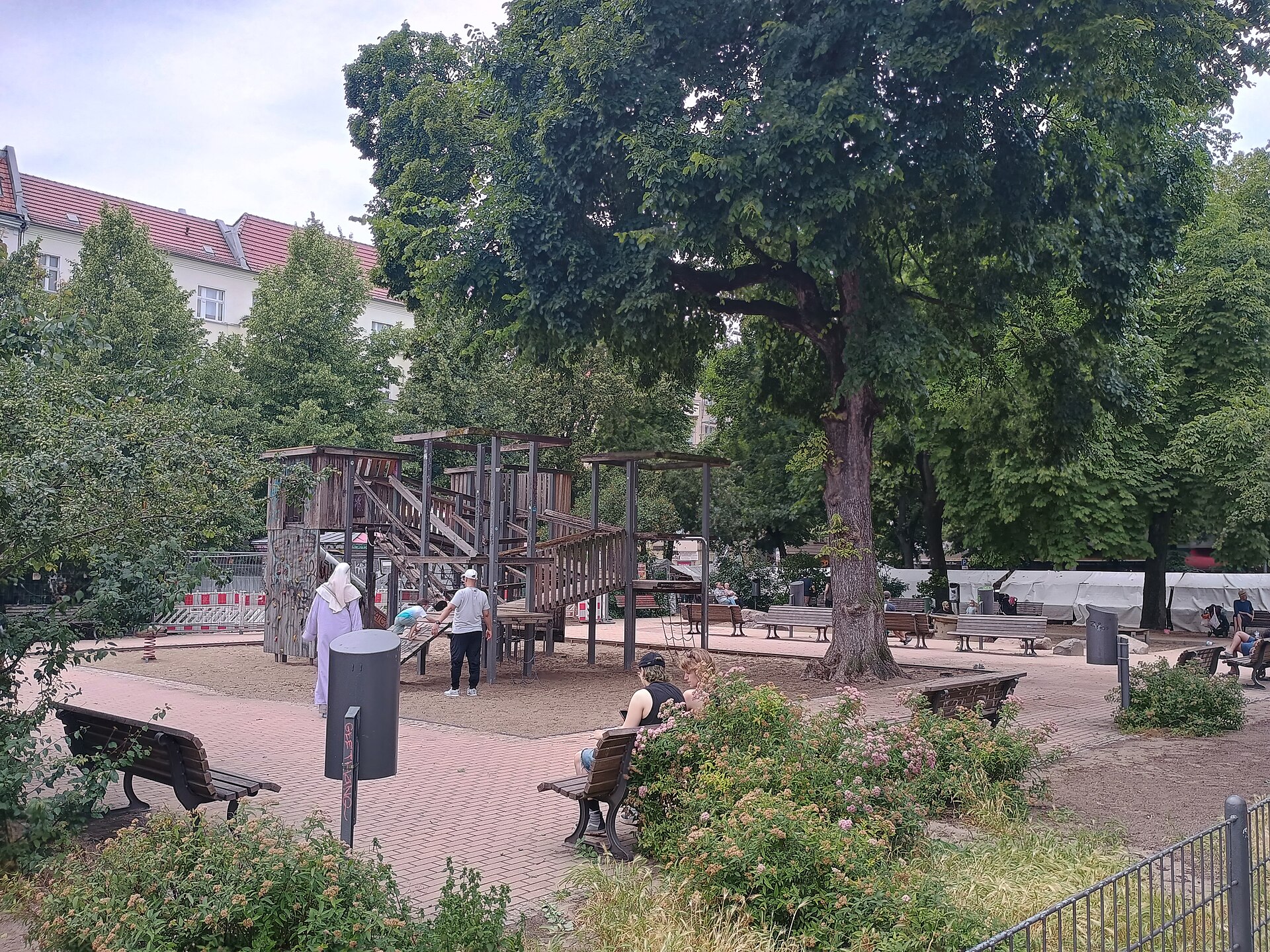 Families and benches around a wooden playground on Boxhagener Platz in Friedrichshain
