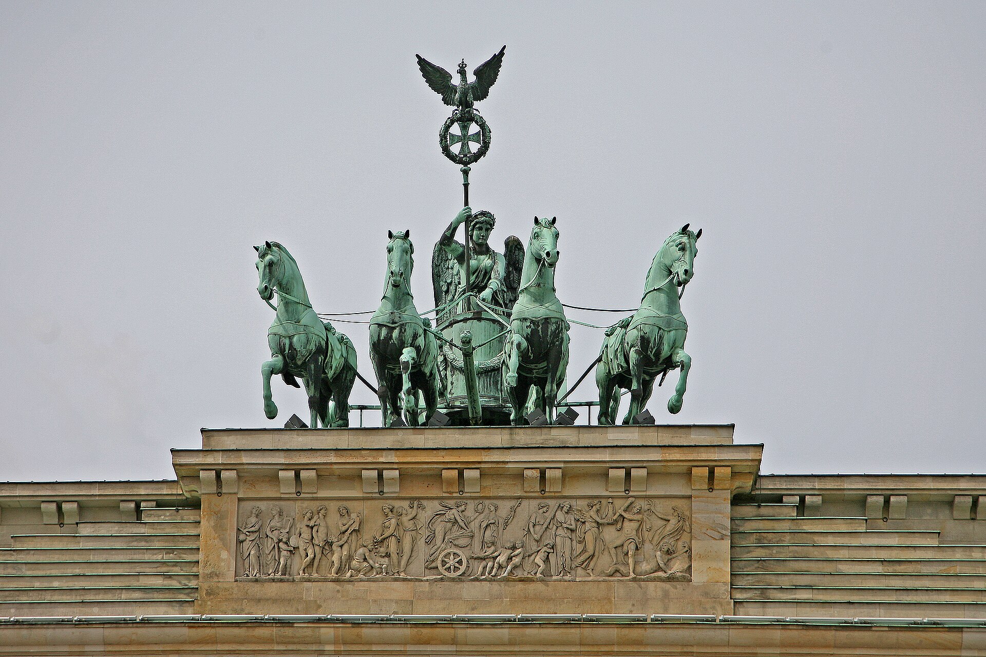 Close view of the Quadriga sculpture on top of the Brandenburg Gate, a winged figure driving four bronze horses